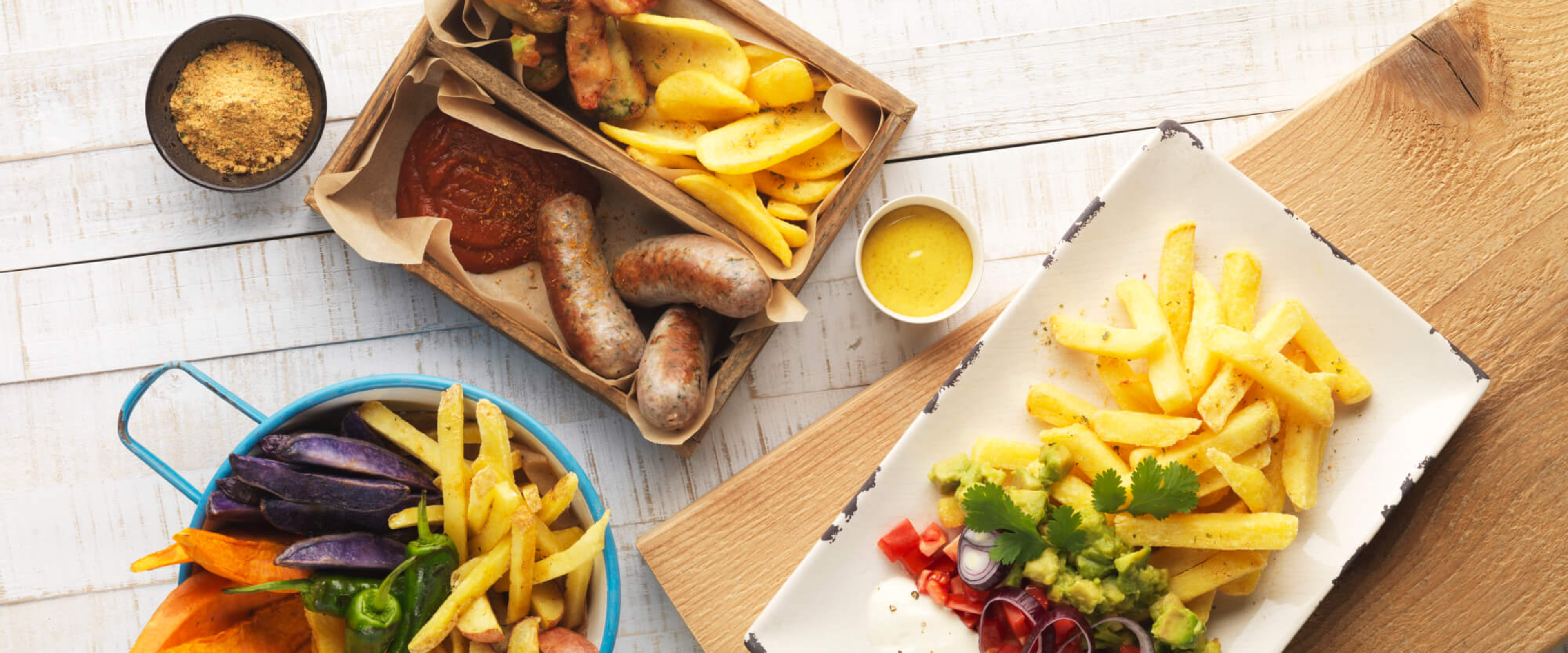 Pommes Frites und Bratwurst mit Streuwürze, dazu Süsskartoffeln und leckere Dips.